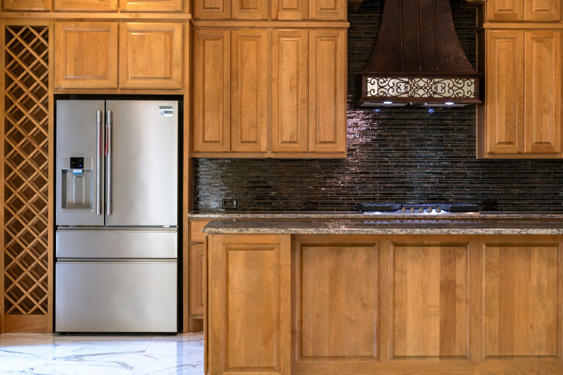 A beautiful kitchen has wooden cabinets and stainless steel.